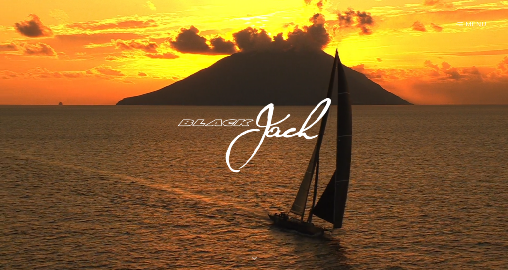 The Black Jack homepage on desktop, with the sailing yacht at sunset in front of a volcano