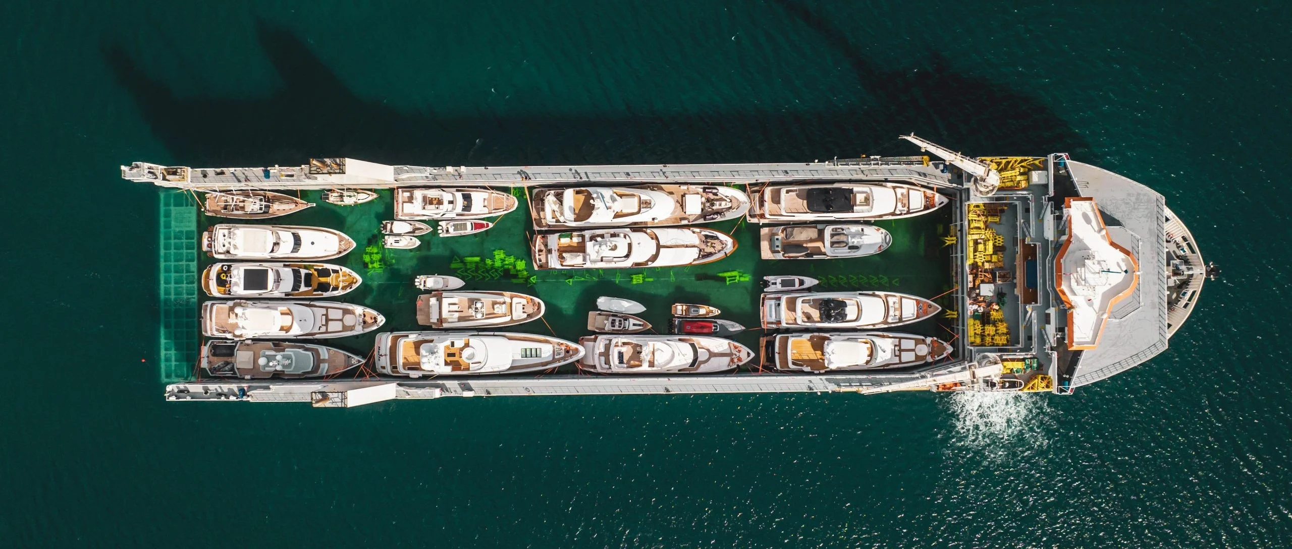Aerial photo straight from above: the deck of the ship completely filled with superyachts