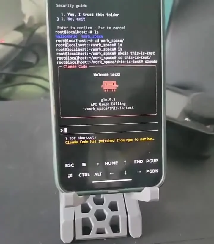 Telefoon in een houder met daarop een terminal waarin Claude Code openstaat in een map met de naam this-is-test en het model glm-5.1 in de statusbalk
