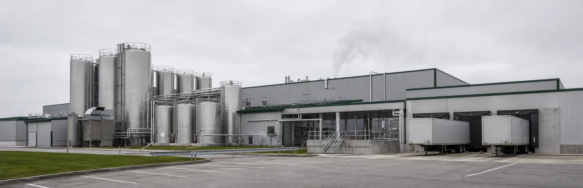 A production site seen from the outside, with silos, process pipework and loading docks