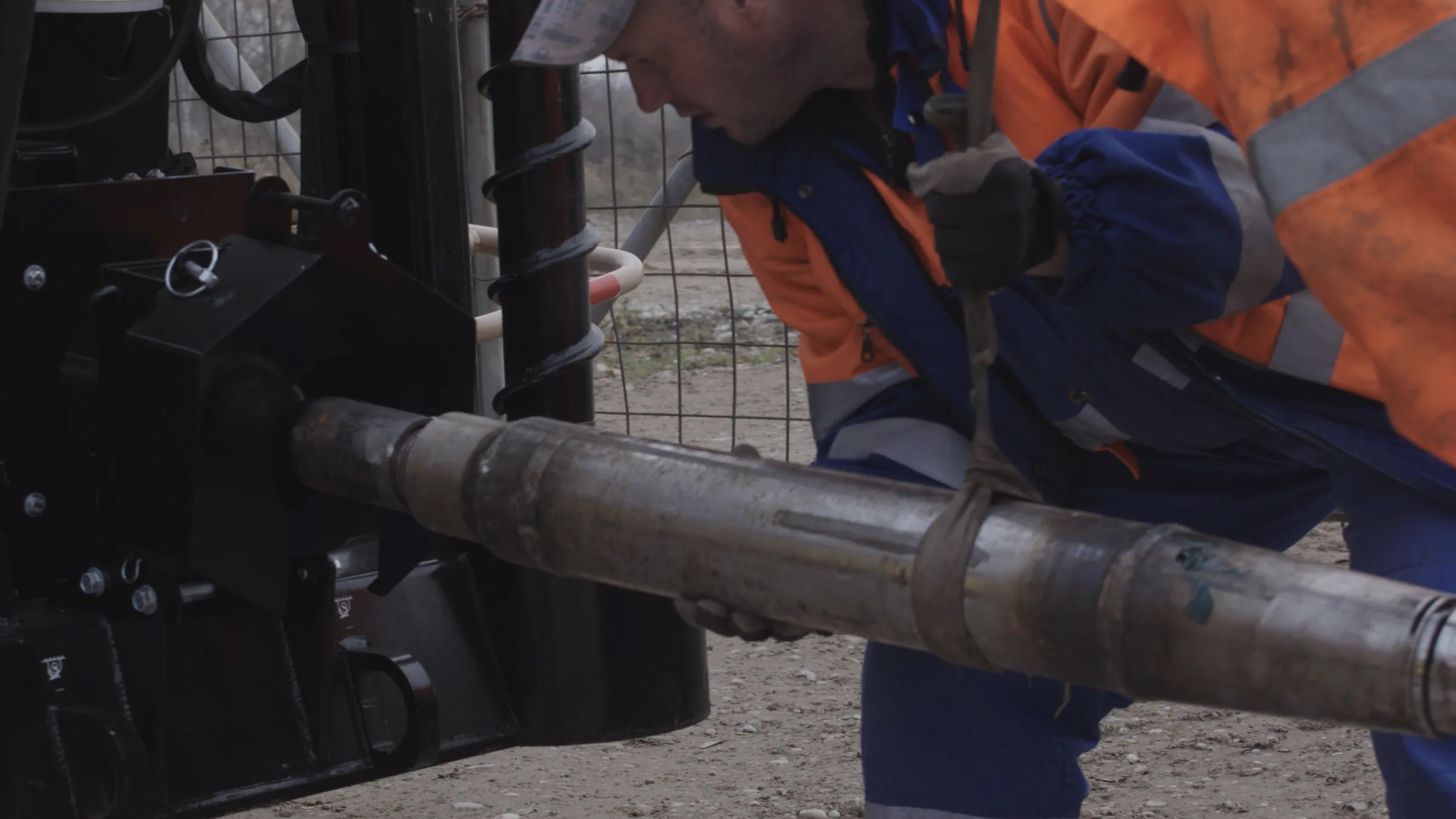 Field engineer connecting a drill rod to the horizontal drilling machine