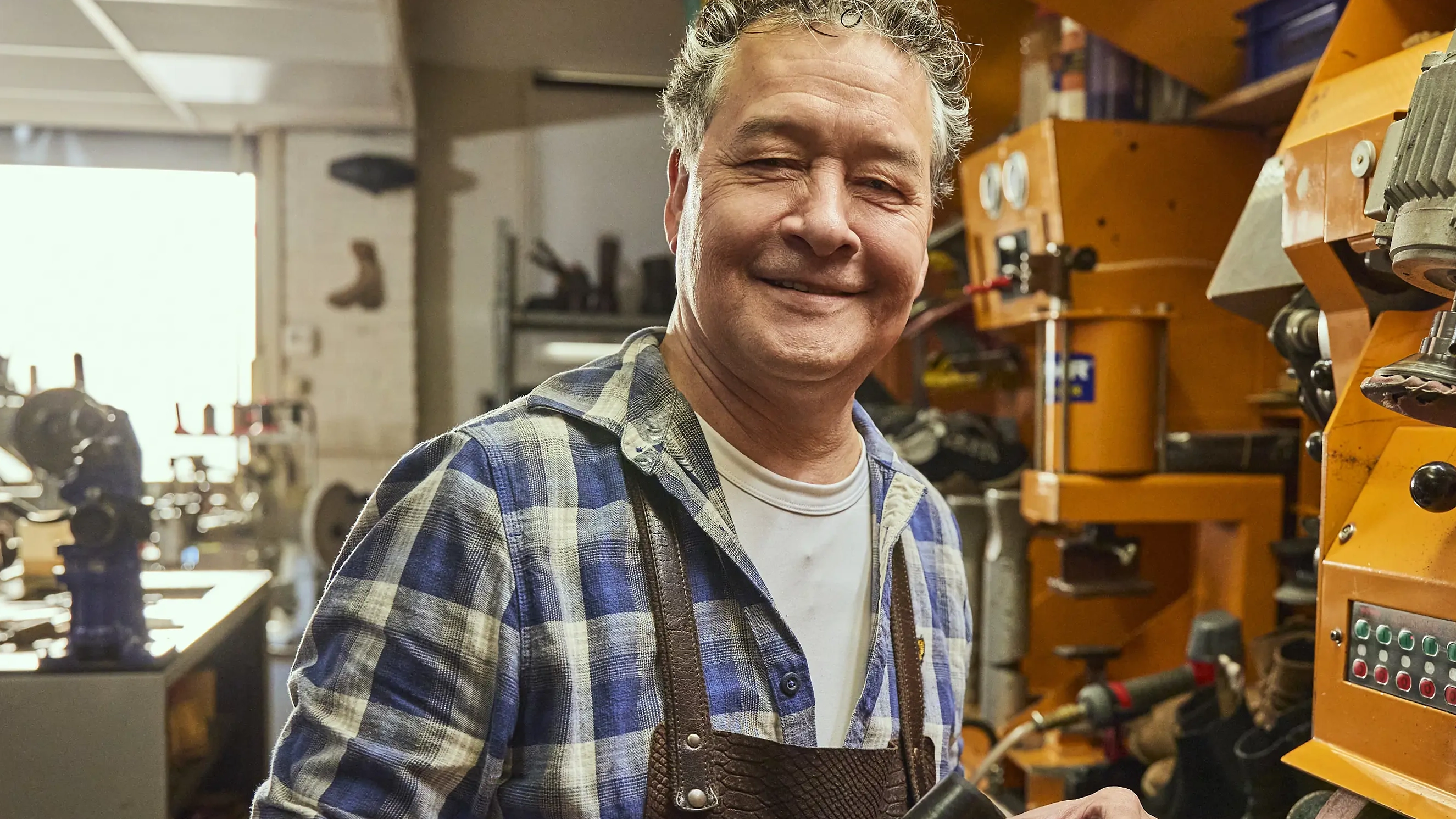 Shoemaker in his workshop beside his machines