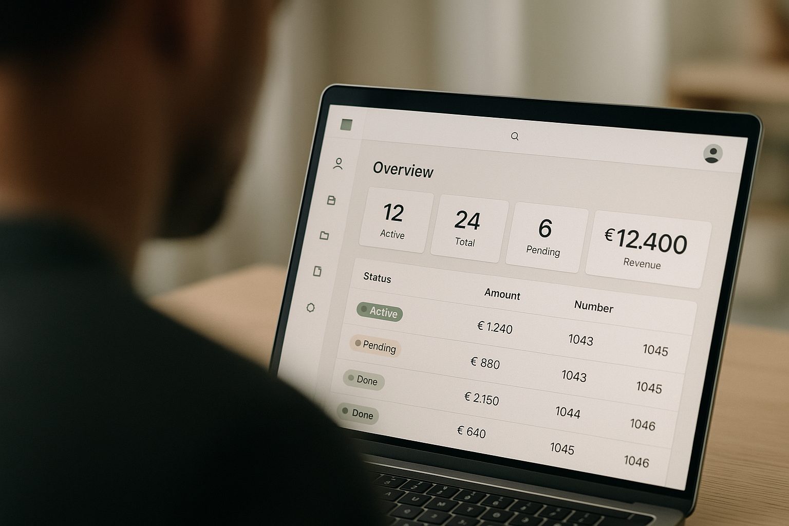 Someone looking at a client portal dashboard with a status table, KPI tiles and navigation on a laptop