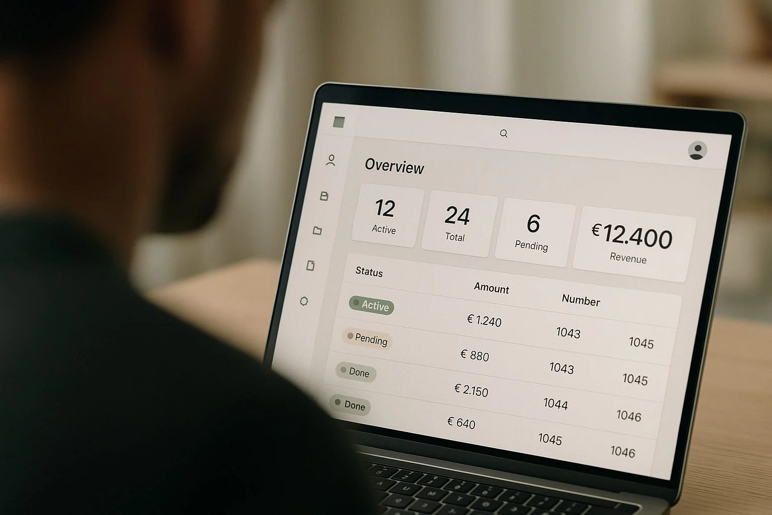 Iemand bekijkt een klantportaal-dashboard met statustabel, KPI-tegels en navigatie op een laptop